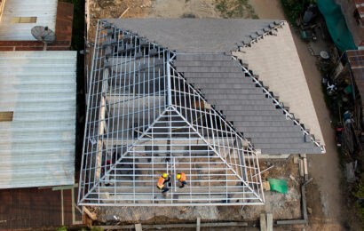 Top view, teamwork of roof tiles construction worker standing on a roof covering it with tiles