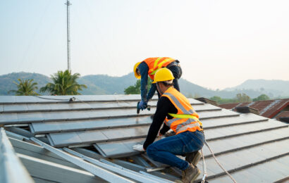 Roofer worker in special protective workwear and gloves installi